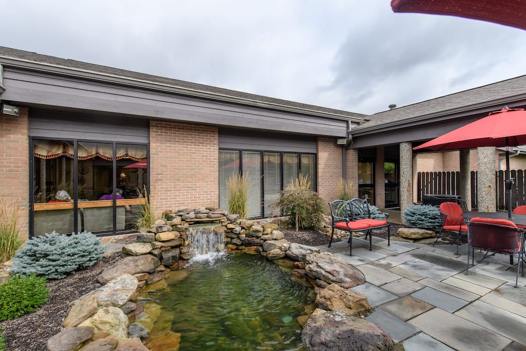 senior living patio and waterfall at The Inn at Belden Village