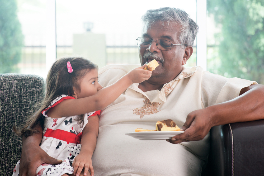 Assisted living resident eating with granddaughter during visiting hours